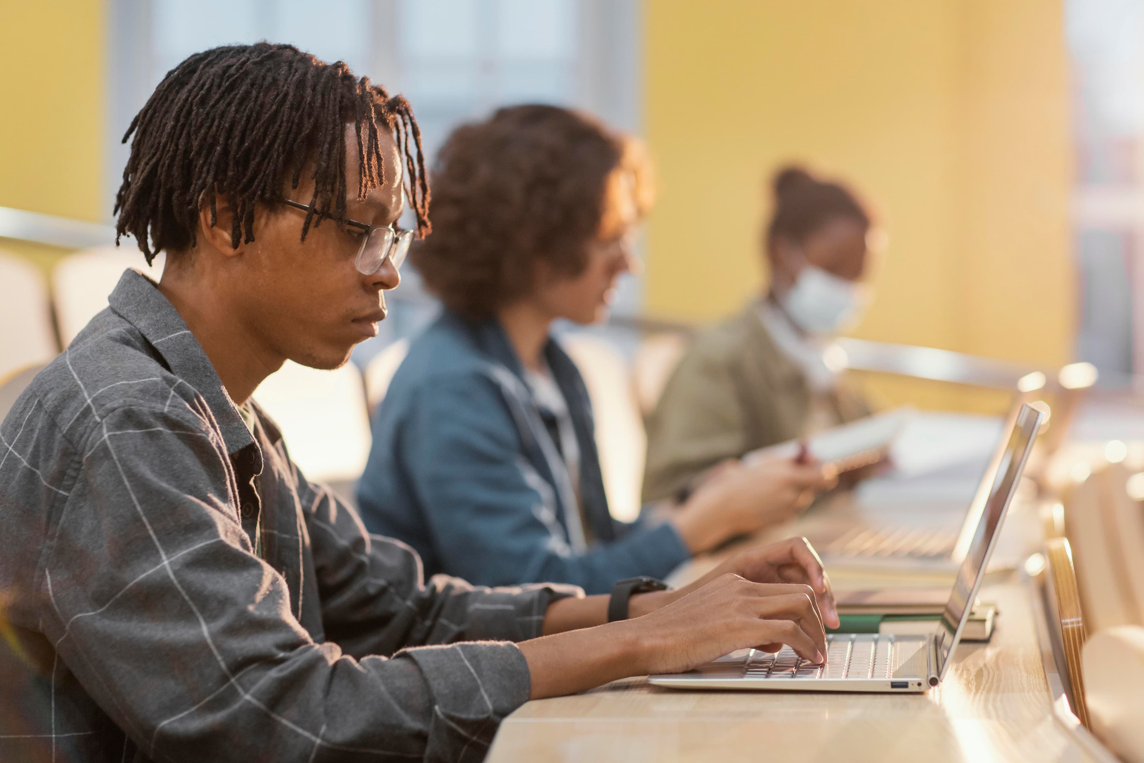 Students studying focused on laptops